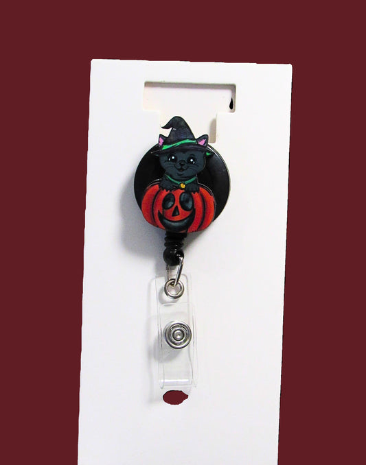 Witch Cat in a Pumpkin Shaped Sublimated Badge Reel